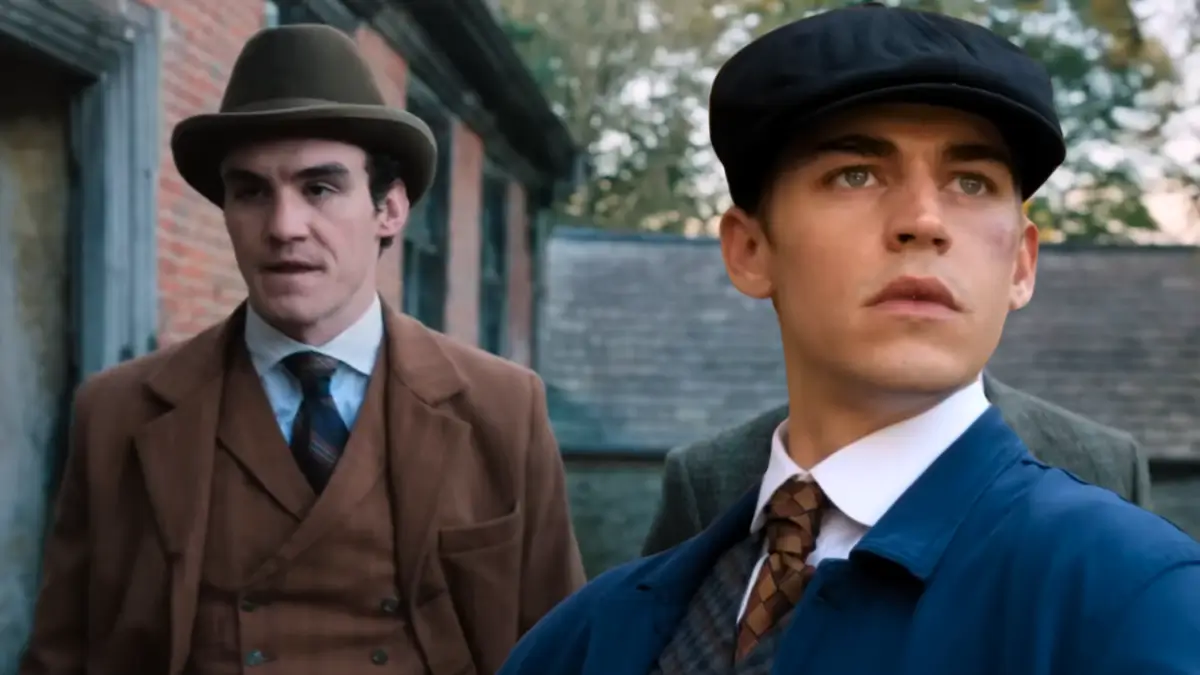 Young Sherlock series scene: two men in Victorian attire standing in brick alley, one in bowler hat, other in flat cap with intense expression