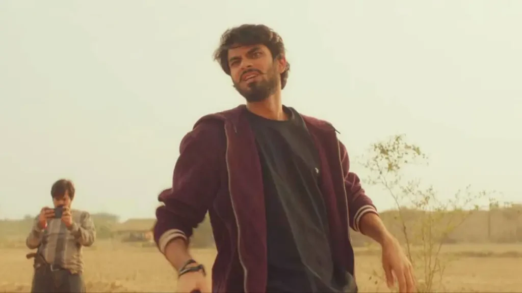 Subedar Movie Review: अनिल कपूर की 'सूबेदार' प्राइम वीडियो पर रिलीज, जानें कैसी है यह एक्शन थ्रिलर फिल्म? 2 Subedaar movie scene: Young man in maroon jacket walking intensely in rural field, angry expression, action drama moment