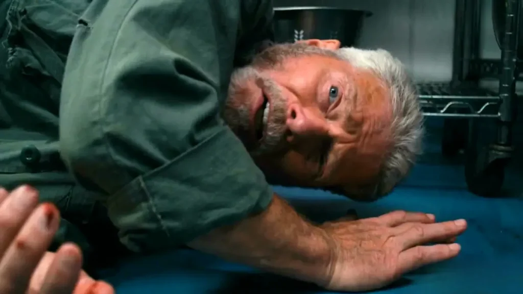 Hellfire 2026 movie scene: Dolph Lundgren as corrupt sheriff lying injured on kitchen floor, intense fight aftermath